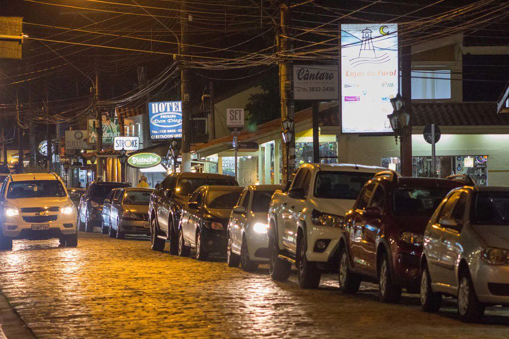 Rua Guarani, no Itaguá, com árvores e lojas dos dois lados.
