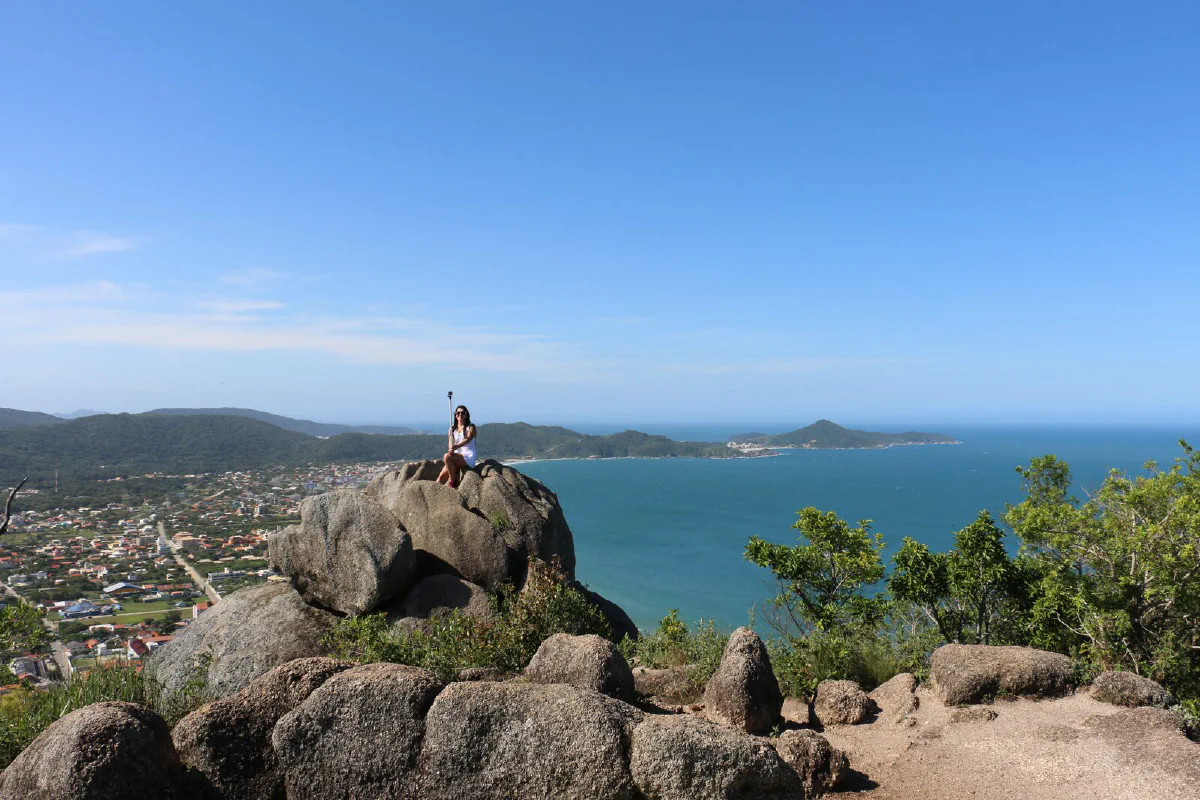 Pedras no topo do Morro do Macaco, com a cidade e o mar ao fundo.