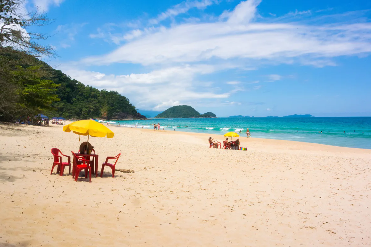 Praia do Félix, em Ubatuba (SP), em dia de sol, com areia clara e mar azul