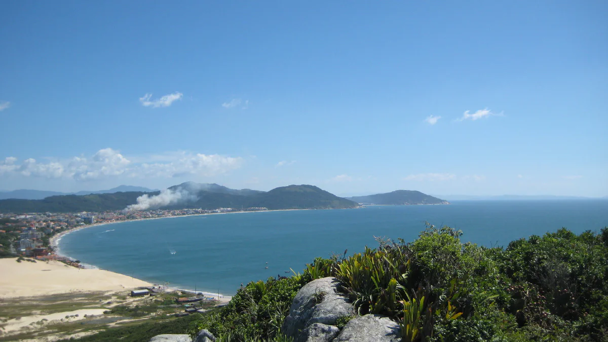 O arco da Praia dos Ingleses visto do alto, com o bairro atrás da praia.