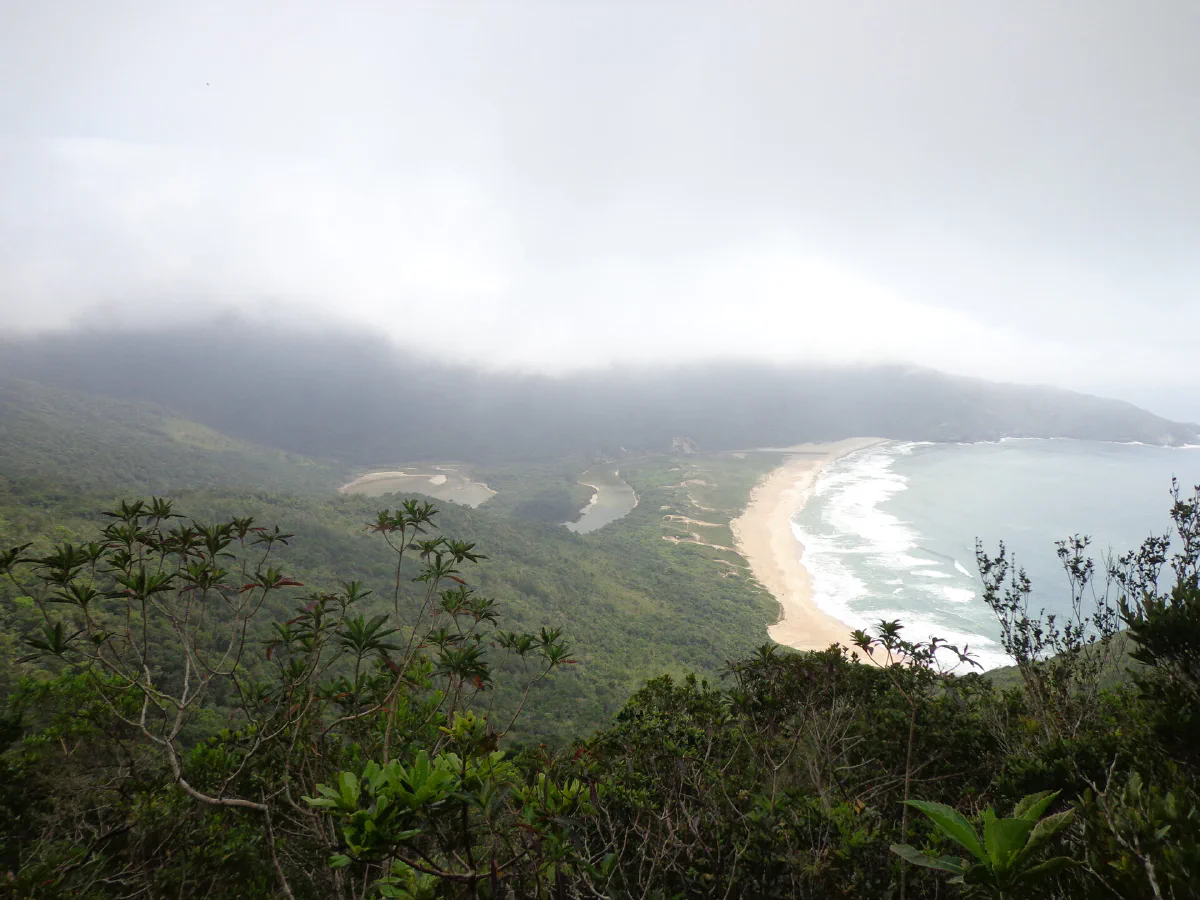 A lagoa, a faixa de areia e o mar vistos do alto, num dia nublado.